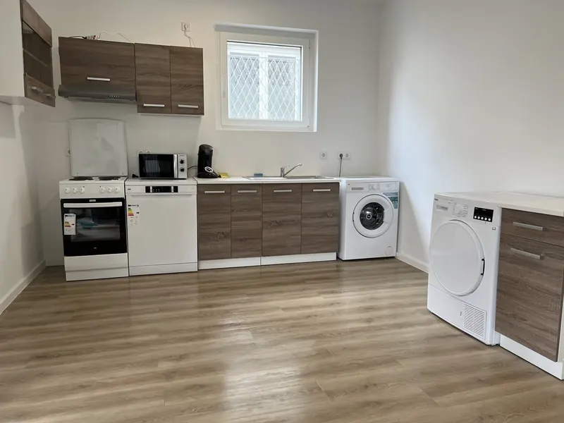 Küche einer Monteurwohnung mit Waschmaschine und Trockner